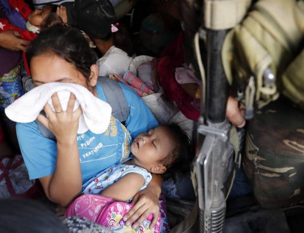 필리핀 알바이주 기노바탄군에서 주민 대피 작전이 진행 중인 가운데 한 엄마가 아이를 안은 채 입과 코를 가리고 있다. 기노바탄|EPA연합뉴스