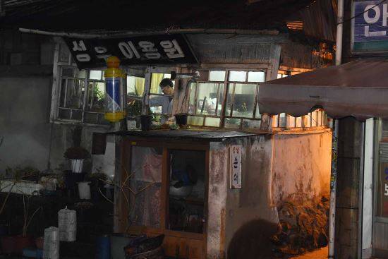하루 일과를 마친 이 씨가 아내와 함께 삶의 터전인 이발소 내부를 정리하고 있다.