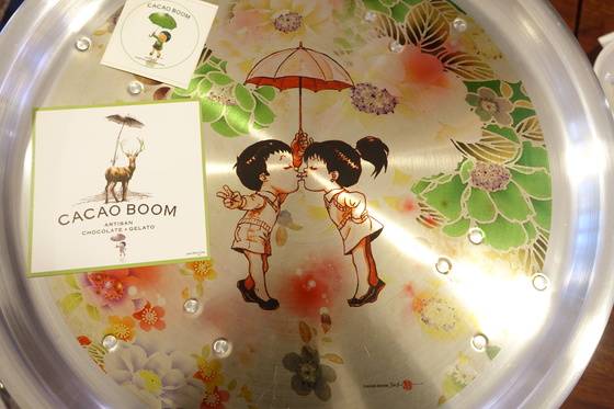 융 에넹의 그림으로 채워진 양은 상. 만화 주인공 소년·소녀는 검정 고무신을 신고 있다. 캐릭터들은 사슴까지도 우산을 쓰고 있다. 고 대표는 ’우산이 융에게는 늘 그리운 어머니의 품 같은 장치인 듯하다“고 설명했다. 그림 아래 융의 서명과 한국 이름 ‘전정식’ 낙관이 찍혀있다.