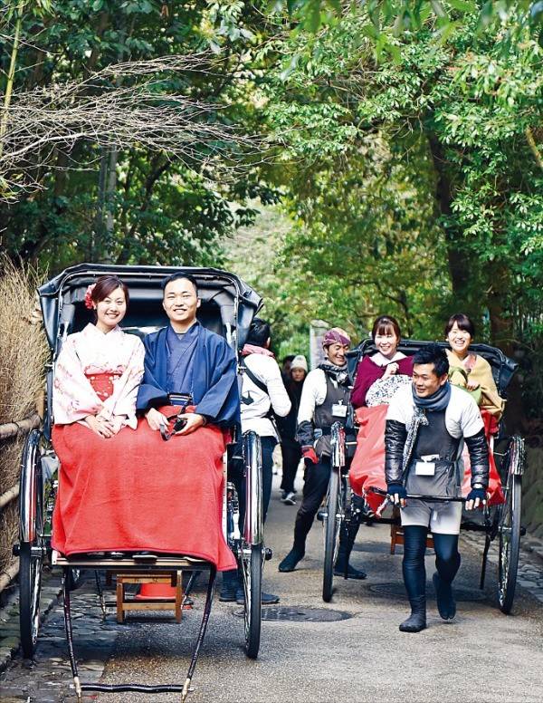 전통 복장인 기모노를 입고 인력거 투어를 즐기는 사람들