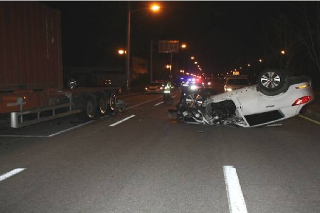 지난 28일 오전 5시께 전북 남원시 한 도로에서 이모(28) 씨가 몰던 승용차가 불법주차돼 있던 25t 트레일러를 들이받고 전복돼 있다. 사진 왼편에 사고를 당한 트레일러의 모습이 보인다. (사진=전북지방경찰청 제공)