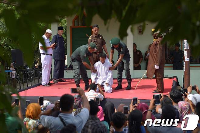 지난해 11월 인도네시아 아체주 반다아체에서 간통 혐의로 한 남성이 태형을 받고 있다. © AFP=뉴스1