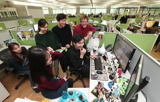 네이버웹툰 사무실에서 김준구 대표(가운데 빨간 상의)가 직원들과 이야기를 하고 있다. 최승식 기자