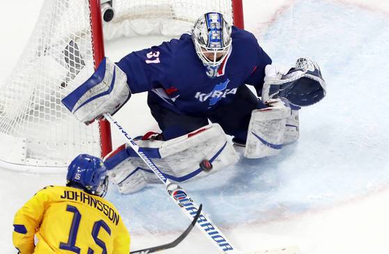 12일 오후 강원도 강릉시 관동하키센터에서 열린 2018 평창동계올림픽 여자 아이스하키 조별예선 2차전 남북 단일팀과 스웨덴 경기에서 단일팀 골리(골피퍼) 신소정이 스웨덴 리사 요한손의 슈팅을 다리로 막아내고 있다. [강릉=연합뉴스]