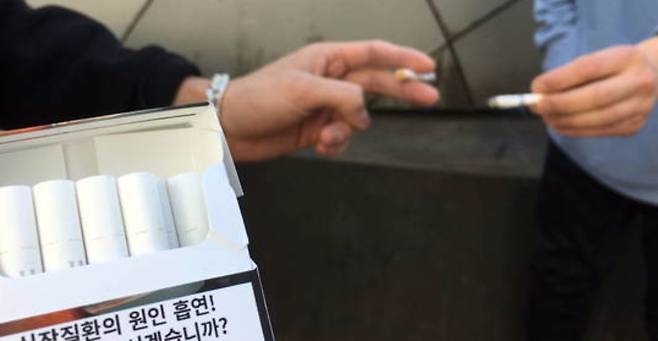 길거리에서 담배를 피우는 흡연자들. 궐련 소비량은 줄어드는 추세인 반면 궐련형 전자담배는 증가하고 있다. [중앙포토]