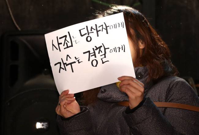 성추행 파문을 일으킨 연극연출가 이윤택의 기자회견이 열린 19일 오전 서울 종로구 30스튜디오에서 한 여성이 ‘사죄는 당사자에게 자수는 경찰에게’라고 적힌 손팻말을 들고 있다. [사진=연합뉴스]