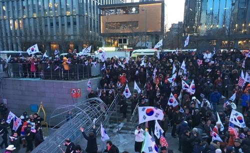 촛불조형물 파손하는 태극기집회 참가자들 (서울=연합뉴스) 권영전 기자 = 보수단체 태극기집회 참가자들이 1일 오후 6시께 서울 종로구 광화문역 해치마당에서 광화문광장에 있던 촛불 조형물을 끌어내려 파손하고 있다. 2018.3.1 comma@yna.co.kr