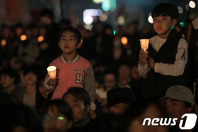촛불집회 1주년을 하루 앞두고 28일 오후 서울 광화문광장에서 열린 '촛불 1주년 대회, 촛불은 계속된다'에서 참가자들이 촛불을 들고 있다. 2017.10.28/뉴스1 © News1 이승배 기자