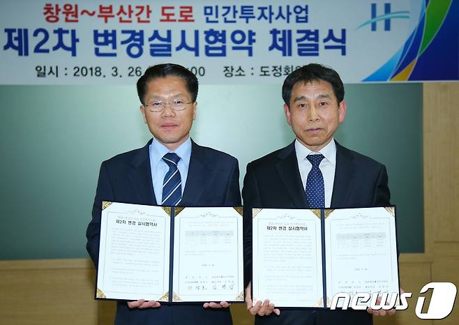 한경호 도지사 권한대행(왼쪽)이 26일 도정회의실에서 경남하이웨이(주)와 창원~부산 간 민자도로인 불모산터널 통행료 요금 인하 협약을 체결한 뒤 기념사진을 찍고 있다.(경남도 제공)2018.3.26./뉴스1 © News1