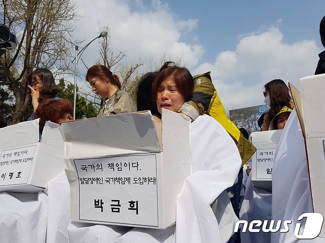 '세계 자폐증 인식의 날'인 2일 오후 서울 종로구 효자치안센터 앞에서 열린 '발달장애인 국가책임제 도입 촉구 전국 1박2일 집중 결의대회'에서 삭발식을 앞둔 학부모가 눈물을 흘리고 있다. 2018.4.2/뉴스1 © News1 윤다정 기자