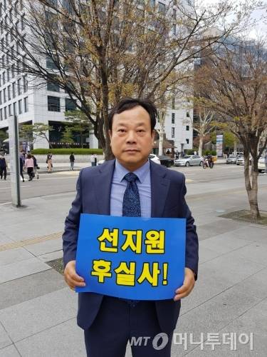 문승 한국GM 부품협력업체 비상대책위원회 위원장이 3일 서울 여의도에서 열린 '한국GM 경영정상화를 위한 협력업체 결의대회'에서 피켓을 들고 서 있다./사진=황시영 기자