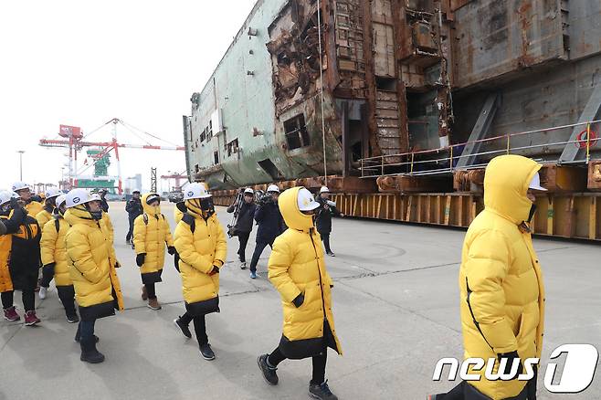 21일 오전 세월호 참사 유가족들이 전남 목포신항만에서 부두와 수직방향으로 거치돼 있던 세월호가 부두 안벽쪽으로 수평 이동한 세월호를 살펴보고 있다. 현대삼호중공업은 오는 5월 31일까지 해상크레인을 이용해 세월호 선체를 바로 세운다. 2018.2.21/뉴 © News1 남성진 기자