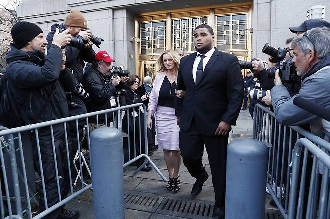 스토미 대니얼스(본명 스테퍼니 클리퍼드)가 경호원과 함께 16일(현지시각) 뉴욕 맨하탄 연방법원을 나서고 있다. 출석할 때와 달리 철제 가드레일이 설치되어 있다. [EPA=연합뉴스]