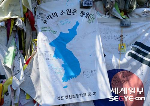 남·북정상회담을 이틀 앞둔 25일 경기도 파주 임진각 자유의 다리를 찾은 관광객들이 벽에 붙은 통일 염원 메시지를 보고 있다.