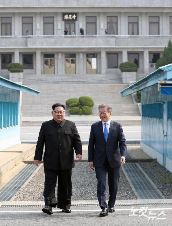 문재인 대통령과 김정은 국무위원장이 27일 판문점에서 만나 공식환영식장으로 이동하고 있다. (판문점=한국공동사진기자단)