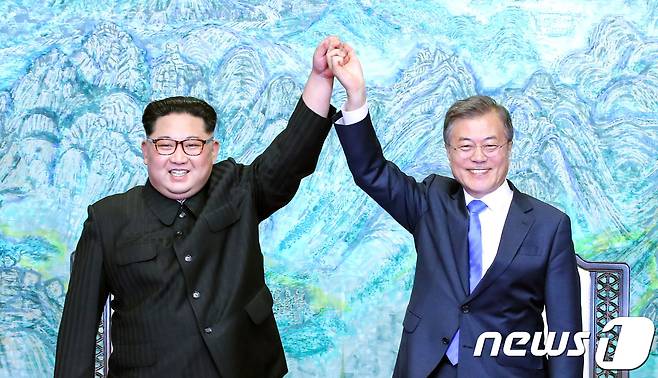 문재인 대통령(오른쪽)과 김정은 북한 국무위원장이 지난달 27일 판문점 평화의 집에서 열린 '한반도의 평화와 번영, 통일을 위한 판문점 선언' 서명식에서 선언문에 서명한 후 손을 맞잡고 들어보이고 있다. 2018.4.27/뉴스1 © News1 한국공동사진기자단