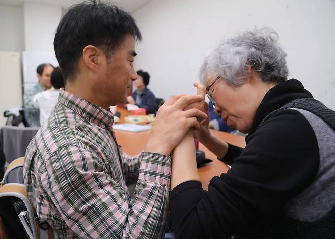 시청각장애인 이철성씨(왼쪽)와 촉수화 통역 자원봉사자인 최인옥씨가 손으로 대화를 나누고 있다. 최승식 기자