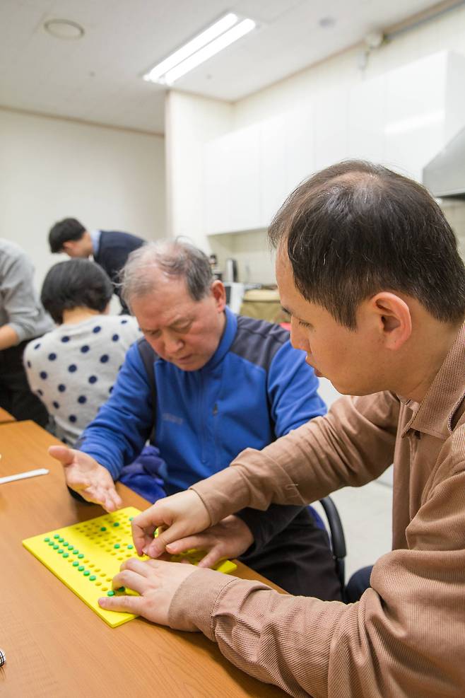 시청각장애인이 서로 점자를 가르쳐주고 배우는 모습. [사진 한국장애인개발원]