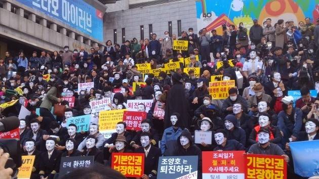 대한항공 직원들이 마스크를 쓰고 조양호 일가 퇴진을 요구하는 피켓을 들고 있다