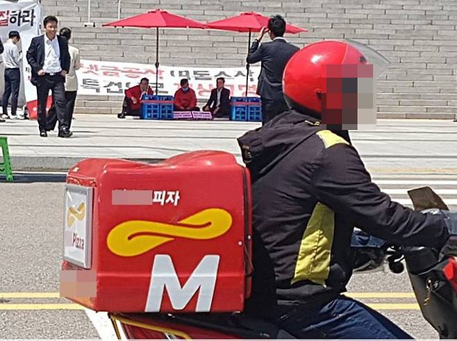 4일 서울 여의도 국회 계단 앞에서 이틀째 단식 농성중인 김성태 자유한국당 원내대표의 농성장으로 불명의 피자가 배달되어 당직자가 확인 후 돌려 보내고 있다. [뉴스1]