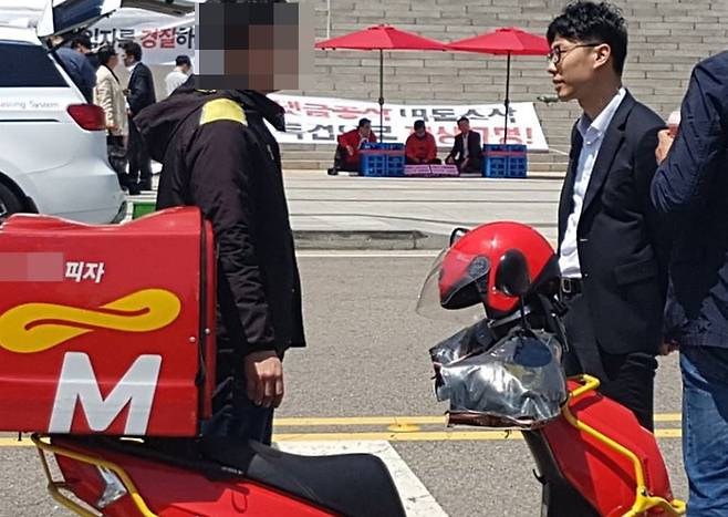 4일 서울 여의도 국회 계단 앞에서 이틀째 단식 농성중인 김성태 자유한국당 원내대표의 농성장으로 불명의 피자가 배달되어 당직자가 확인 후 돌려 보내고 있다. [뉴스1]