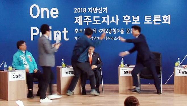 지난 14일 오후 제주시 벤처마루에서 열린 ‘2018 지방선거 제주도지사 후보 토론회’에서 제주 제2공항 반대 활동을 했던 김모 씨가 무대에 올라가 원희룡 예비후보를 폭행하고 있다 (사진=연합뉴스)