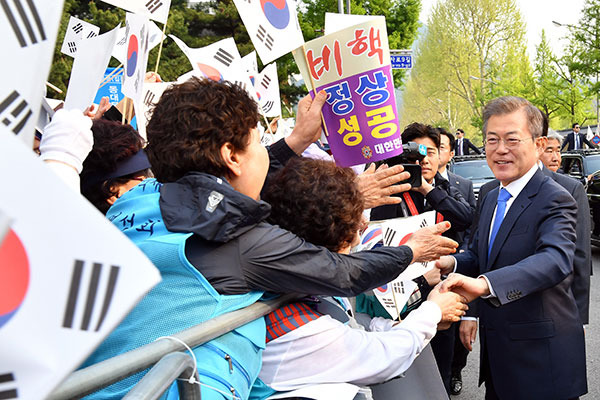 ⓒ한국 공동사진기자단 4월27일 남북 정상회담 성공을 기원하며 나온 시민들과 문재인 대통령이 손을 맞잡고 있다.