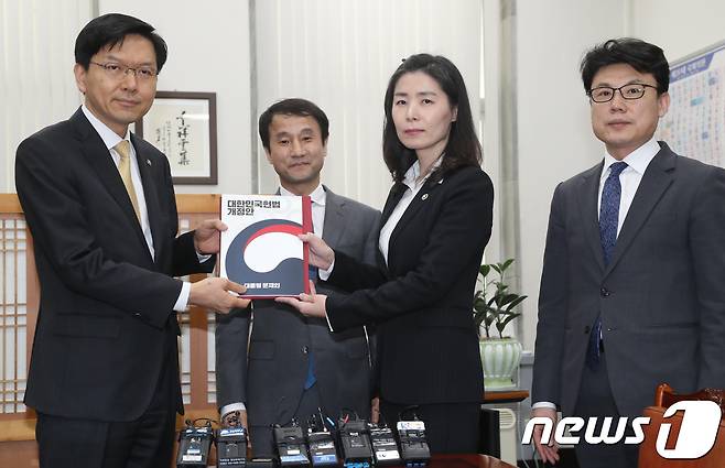 김외숙 법제처장이 26일 오후 `대통령 개헌안'을 국회에 송부하려고 국회 입법차장실을 방문해 진정구 차장에게 대한민국헌법개정안을 제출하고 있다. 2018.3.26/뉴스1 © News1 박정호 기자