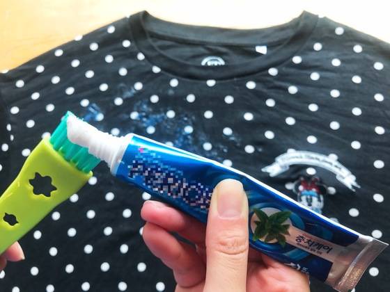 이제 치약이 등장할 순서다. 따뜻한 물에 불린 옷을 바닥에 놓고 솔에 치약을 묻힌다.