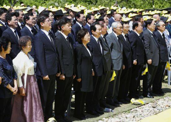 23일 경남 김해시 봉하마을 대통령 묘역에서 엄수된 노무현 전 대통령 9주기 추도식에서 권양숙(왼쪽 다섯번째) 여사, 정세균(왼쪽 여섯번째) 국회의장을 비롯한 참석자들이 '임을 위한 행진곡' 제창을 하고 있다. 뉴시스