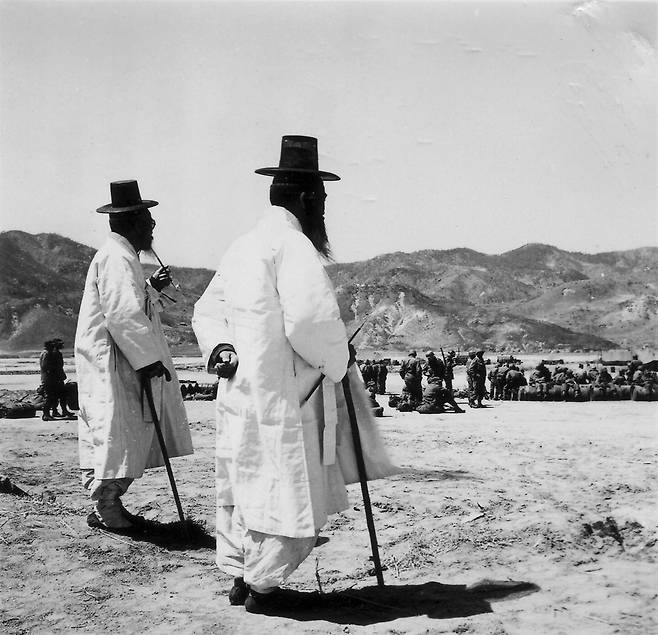 1952. 4. 25. 미군들을 물끄러미 바라보고 있는 한국의 두 노인 ⓒNARA
