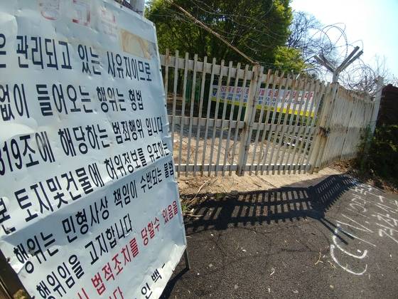 지난 4월말 찾았을 당시의 옛 남양 신경정신병원 정문. 자물쇠로 굳게 잠겨 있다. 옆으로는 무단침입을 금지하는 경고판이 보인다. 김민욱 기자