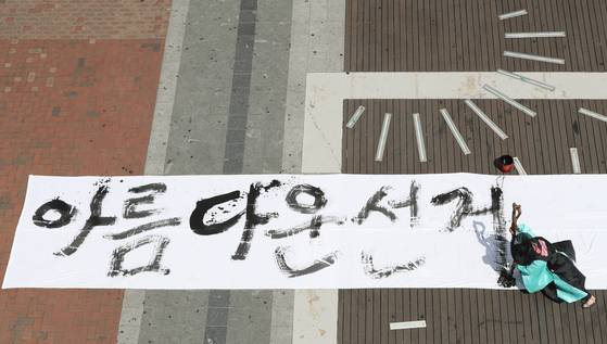 지난달 31일 오후 대구 중구 동성로 대구백화점 앞 광장에서 6·13 지방선거를 앞두고 유권자의 투표 참여를 독려하는 서예 퍼포먼스가 열렸다. 천명문화예술연구소 새암 김지영 이사장이 길이 25m, 폭 2m 크기의 광목천에 ‘아름다운 선거 대한민국의 희망입니다’라는 글을 쓰고 있다. [뉴스1]