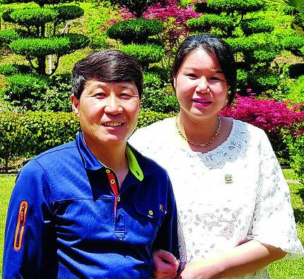 ‘죽도 부부’ 김유곤·이윤정씨는 6일 “아이가 태어나면 건강한 사회구성원이 될 수 있도록 바르게 키우겠다”고 밝혔다. 죽도 자택 앞에서 환하게 웃고 있는 부부의 모습.  김유곤씨 제공