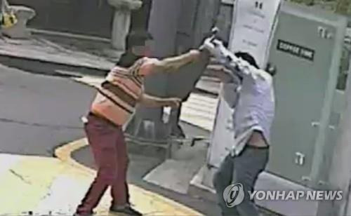 7일 오전 서울 강남구의 한 골목에서 서촌 궁중족발 사장 김모씨가 건물주 이모씨에게 망치를 휘두르는 모습. 서울 강남경찰서는 김씨를 살인미수 등 혐의로 구속했다.[연합뉴스 자료사진]