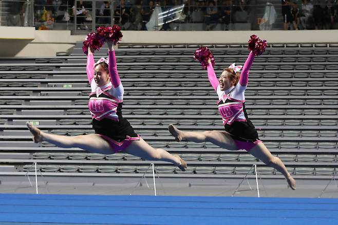 페어 참가자들이 미소를 지으며, 점프 동작을 하고 있다. 선수들간의 통일성이나 무대를 얼마나 효율적으로 사용했는지도 치어리딩의 중요한 평가 요소다. 우상조 기자
