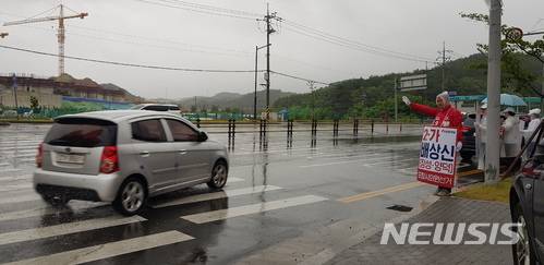 【포항=뉴시스】강진구 기자 = 경북 포항시의회 바선거구(장량동)에 출마한 자유한국당 배상신 후보는 11일 오전  장량동 삼도W사거리에서 우의를 입고 허리를 굽혀 인사하며 지역민들에게 지지를 호소했다.2018.06.11.  dr.kang@newsis.com