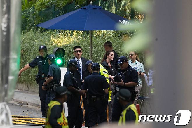 북미정상회담을 하루 앞둔 11일 싱가포르 센토사섬 회담장인 카펠라 호텔 입구에 북한과 미국 경호원을 비롯한 경찰들이 경계근무를 서고 있다. 2018.6.11/뉴스1 © News1 유승관 기자