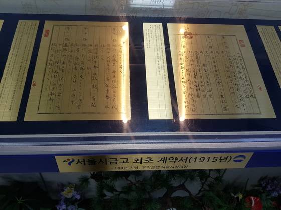 지난 7일 오전 우리은행 서울시청점 입구에 전시돼 있는 계약서. 1915년 조선총독부 경성부와 우리은행의 전신인 조선경성은행이 금고 관리 업무 계약을 맺는다는 내용이다.[이승호 기자]