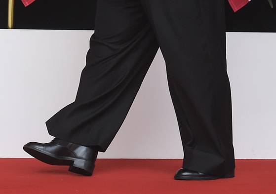 김정은 위원장이 굽을 높은 구두를 신고 걷고 있다. [AP=연합뉴스]