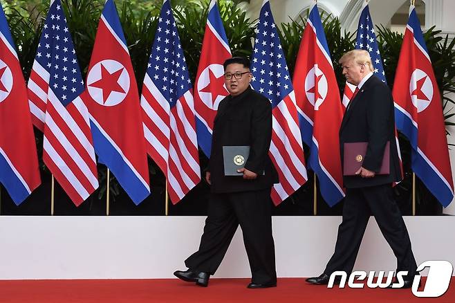 김정은 북한 국무위원장(왼쪽)과 도널드 트럼프 미국 대통령이 지난 12일 싱가포르 카펠라호텔에셔 열린 정상회담 뒤 공동성명에 서명한 후 퇴장하고 있다. © AFP=뉴스1