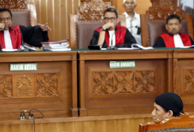 인도네시아 카르타에서 22일(현지시간)  극단주의 무장세력 이슬람국가(IS)를 추종하며 테러 등 혐의로 기소된 이슬람 성직자 아만 압두라흐만이 재판에 출석해 앉아 있다.  재판부는 이날 압두라흐만에게 사형을 선고했다. EPA 연합뉴스