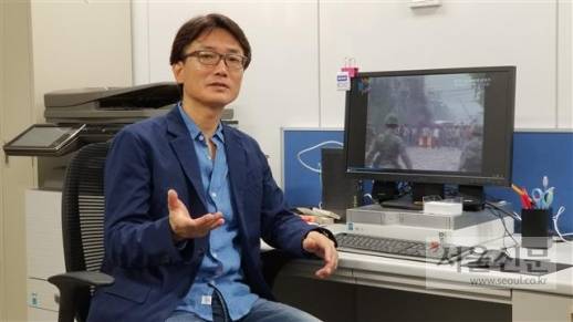 재일 다큐멘터리 연출가 전용승 PD가 21일 다큐멘터리 ‘그때, 시민은 군과 싸웠다’의 영상을 배경으로 제작 과정을 설명하고 있다.