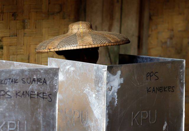 인도네시아 지방선거가 실시된 27일(현지시간) 반텐주 카네케스 마을의 투표소를 찾은  바두이족 여성 유권자가 투표를 하고 있다.  로이터 연합뉴스