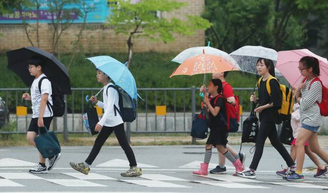덥고 습한 장마철은 곰팡이가 자라기 좋다. 곰팡이는 몸에 침투, 기관지염, 천식, 무좀 등 각종 질환을 일으키는 ‘만병의 근원’이 될 수 있다. 전국 대부분 지역이 장맛비가 내린 지난 26일 오전 세종시 한솔동에서 초등학생들이 우산을 쓰고 등교하고 있다. [연합뉴스]