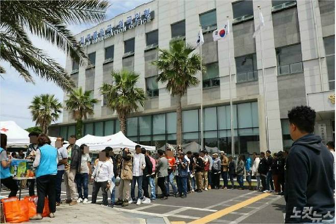 제주출입국·외국인청 앞마당에서 예멘 난민들이 식료품 등의 물품을 받기 위해 줄을 서고 있다. <사진=고상현 기자>
