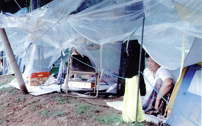 서울 서초동 서울교대 체육관 주변에 텐트를 치고 기거하면서 실종된 가족의 소식만을 애타게 기다려온 한 실종자 가족이 텐트 밖으로 내리는 부슬비를 넋 잃은 표정으로 바라보고 있다. <한겨레> 자료 사진.