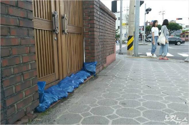 제주시 용담동 주민들은 주택 대문에 모래주머니를 채우며 제7호 태풍 쁘라삐룬의 북상에 대비하고 있다. (고상현 기자)