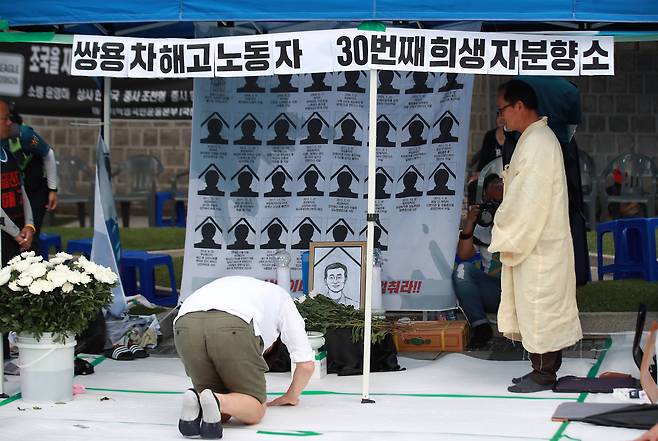 4일 오전 서울 중구 대한문 앞에 마련된 쌍용자동차 해고 노동자 고(故) 김주중씨 추모 분향소에서 한 시민이 조문하고 있다. [연합뉴스]