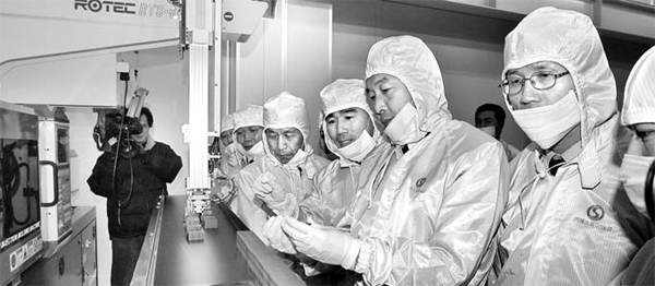 2004년 12월 개성공단 에스제이테크 공장에서 유창근 대표(오른쪽 넷째)와 직원들이 클린룸 사출기에서 생산된 자동차 부품을 검수하고 있다. [사진 제공 = 에스제이테크]